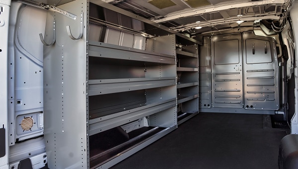 Interior de van con estanterías modulares y ganchos de almacenamiento.